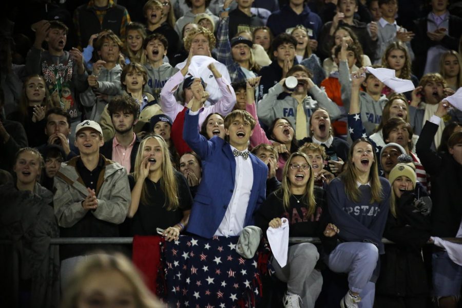 The Gulf Breeze student section cheers on the football team at the rivalry game at Navarre