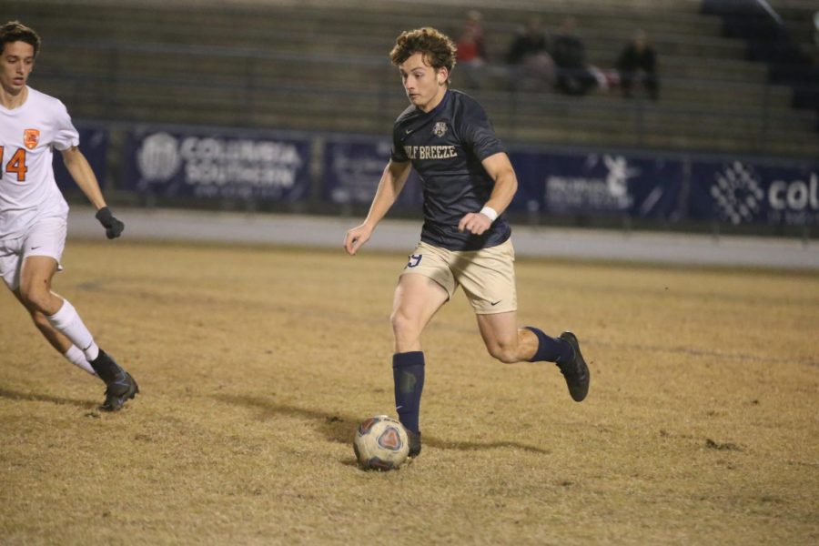 Senior Luke Jacobi takes the ball downfield in the district final against Escambia.