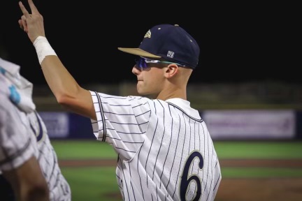 Varsity player Caden Conway signals to his teammate during a home game.