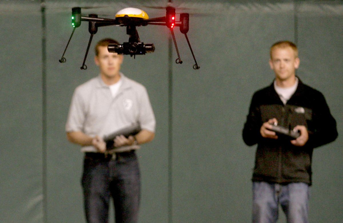 Jake Stoltz, left, and Trevor Woods of the John D. Odegard School of Aerospace Sciences at the University of North Dakota in Grand Forks, remotely pilot a Draganflyer X4ES drone during a demonstration at the Alerus Center in Grand Forks, N.D. on Tuesday, June 24, 2014. They were demonstrating possible law enforcement applications in conjunction with the Grand Forks Police Department, for an unmanned aircraft vehicle conference. Woods is the technical direction of the Northern Plains UAS Test Site, as designated by the Federal Aviation Administration.