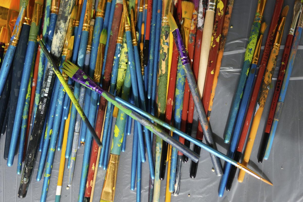 Paintbrushes sit piled after community members painted pieces of a mural on a wall that once segregated the town of South Miami, Fla., and has now been dubbed the Unity Wall, Saturday, Jan. 20, 2024.