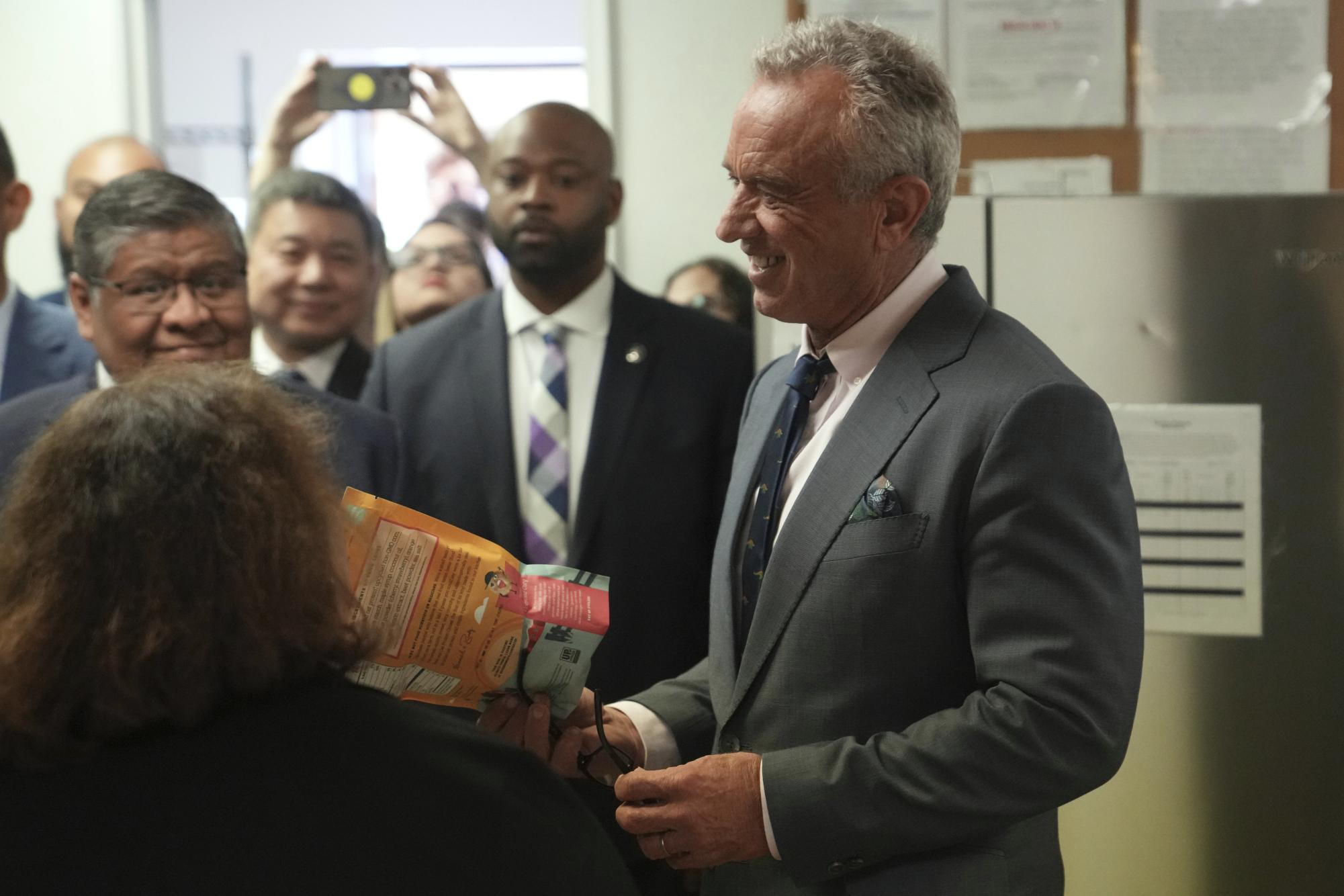 U.S. Health Secretary Robert F. Kennedy Jr. holds a package of food during a tour of the Native Health Mesa Food Distribution Center, in Mesa, Ariz., Tuesday, April 8, 2025. (AP Photo/Ross D. Franklin)