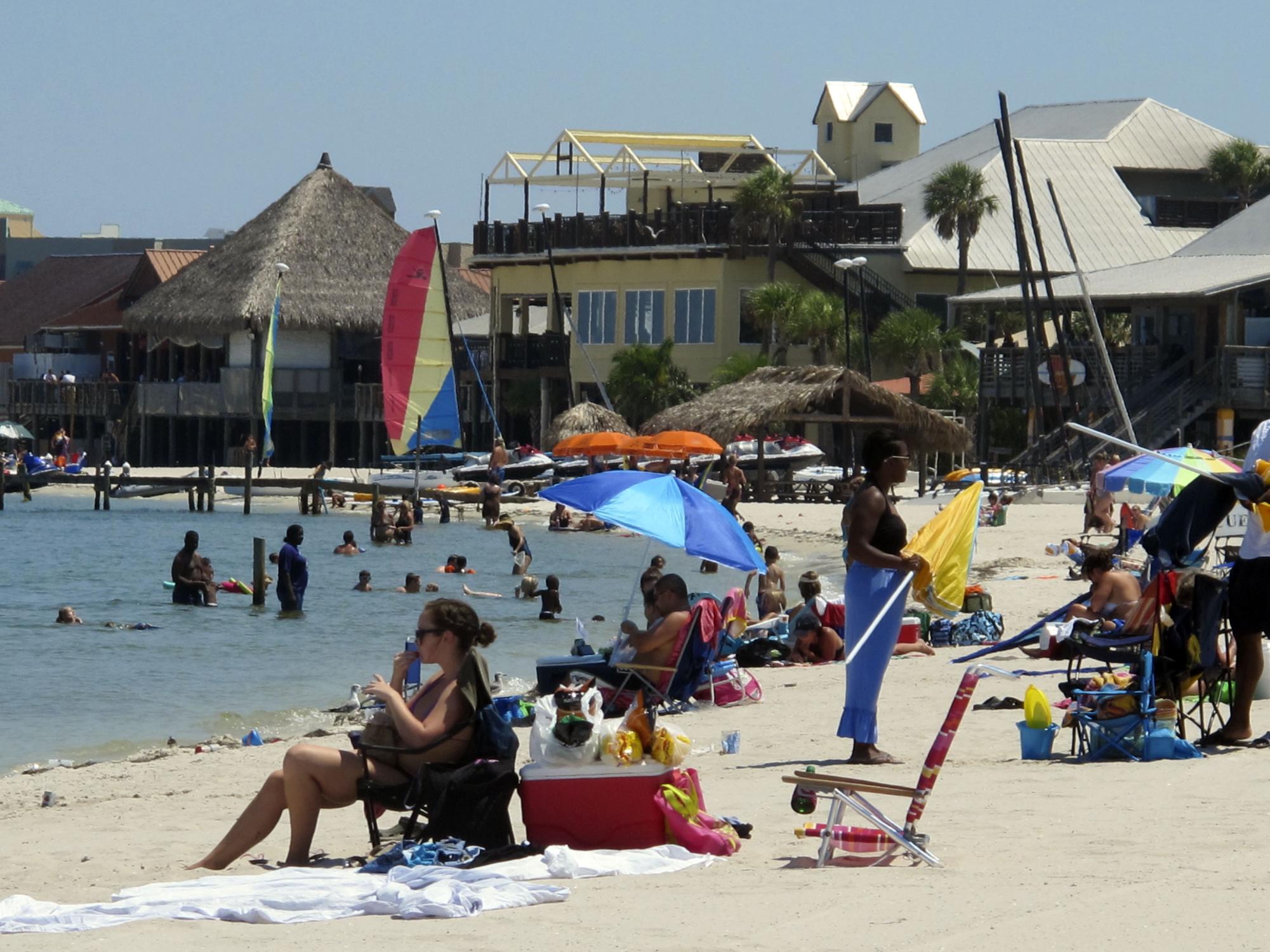 This Sunday, Aug. 28, 2011 photo shows tourists as they sit on the beach at Pensacola Beach, Fla. Beach towns from Alabama through the Florida Panhandle have had a strong summer 2011 rebound after a 2010 marred by tar balls, crude oil sheen and cleanup crews and equipment ruining the views for any would-be sunbathers. (AP Photo/Melissa Nelson)