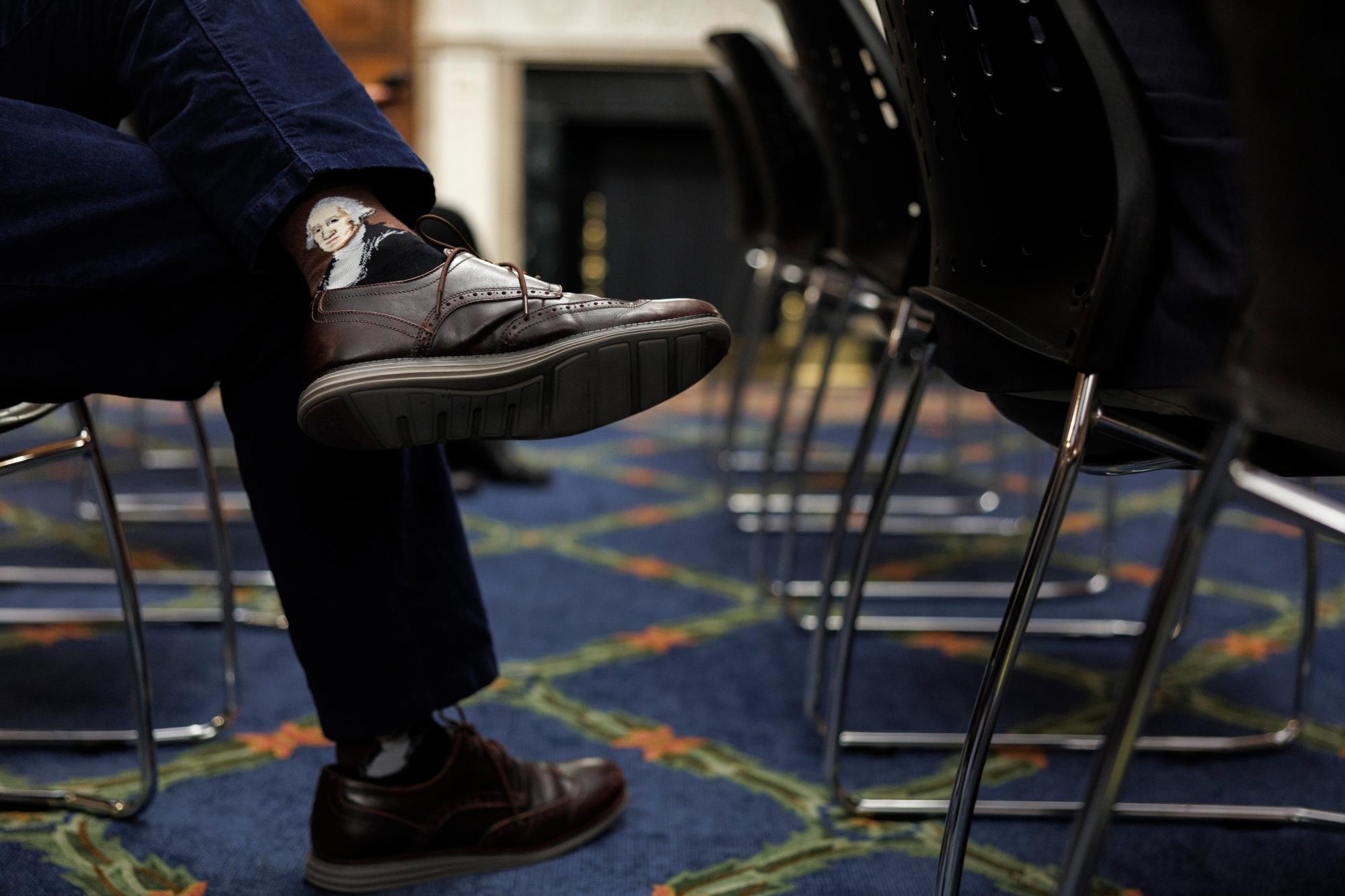 A reporter wears President George Washington themed-socks during a news conference with House Speaker Mike Johnson, R-La., on Capitol Hill in Washington, Wednesday, Feb. 11, 2026, in Washington. (AP Photo/Tom Brenner)